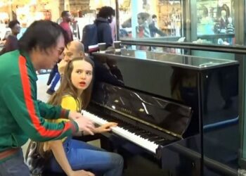 A zöld ruhás ismeretlen félbeszakítja a zongorán játszó fiatal lányt, a mutatványtól a tömeg összecsődül